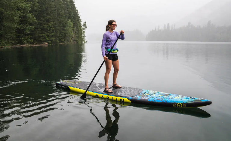Woman in misty bay paddling a standup paddleboard